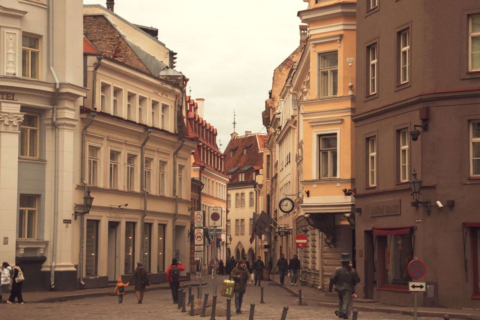 A historic street in Tallinn Old Town with walkers between tall facades, a classic cultural walk in port