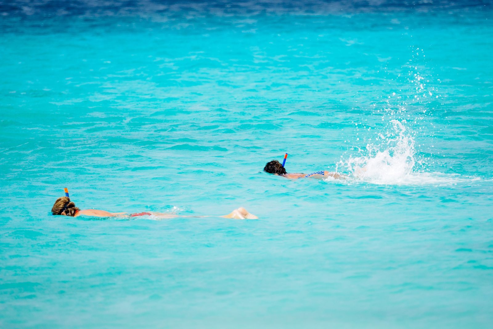 Two snorkellers swimming in bright turquoise water, one of the most popular cruise port activities