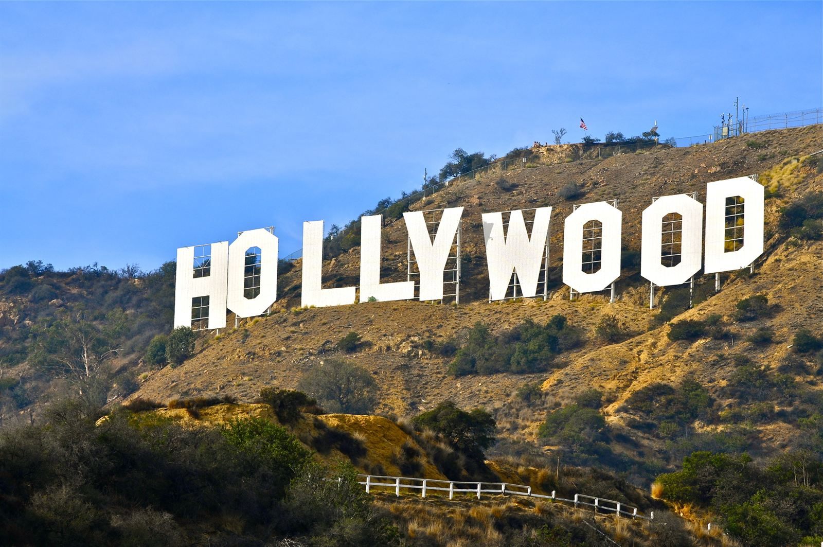 The Hollywood sign on a dry hillside under a blue sky in Los Angeles